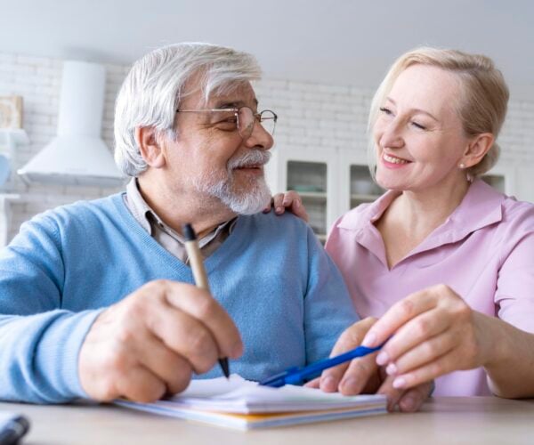 Man and woman in a kitchen with a notebook