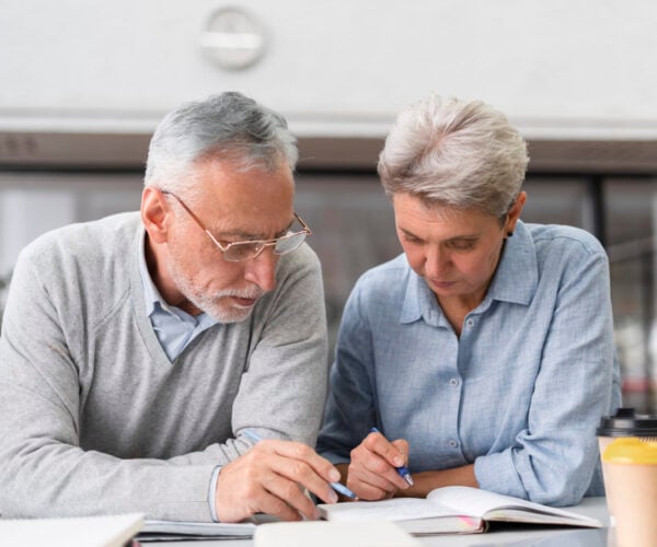 Man and woman in a kitchen reviewing documents